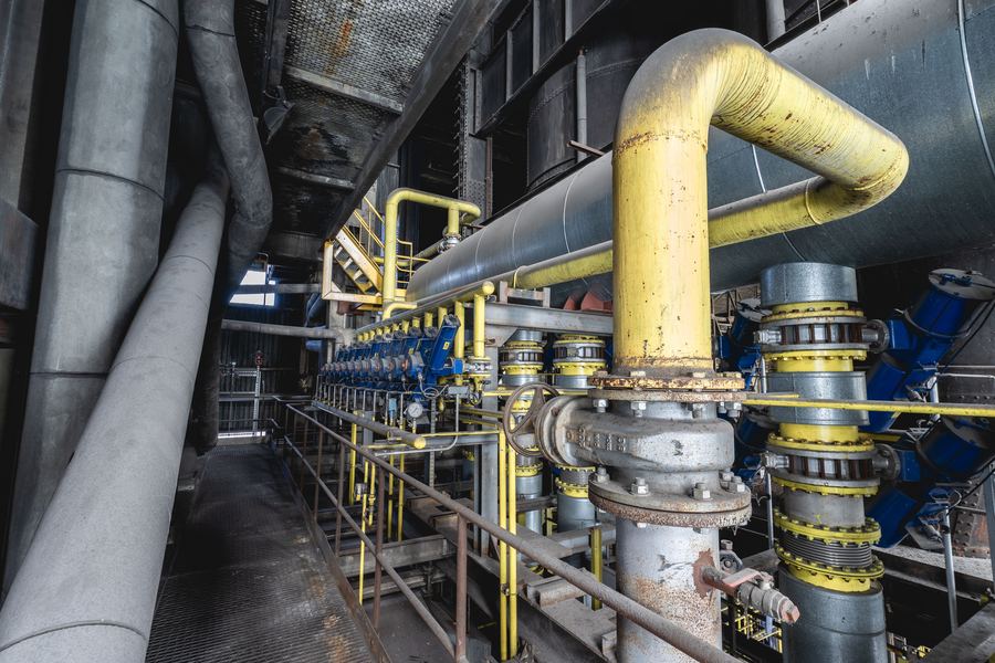 Row of industrial ball and butterfly valves on a piping manifold