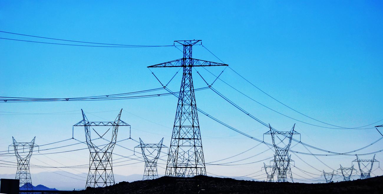 Electricity transmission towers against a clear blue sky