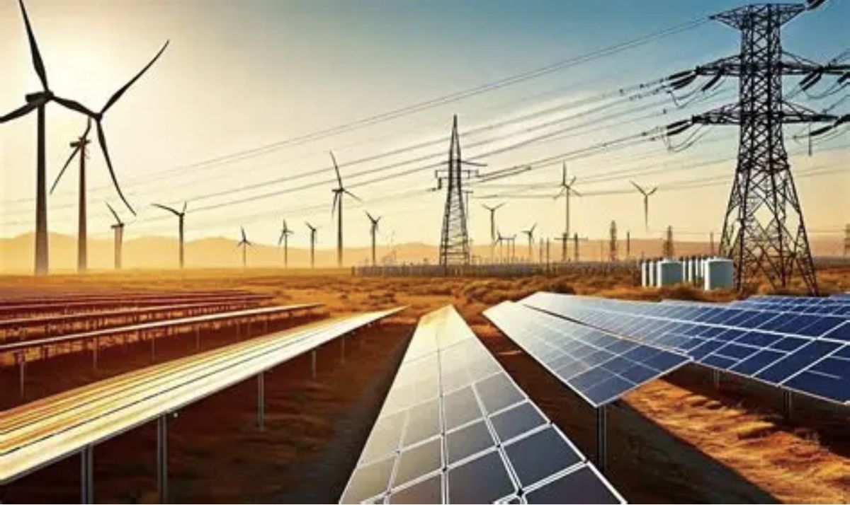 Solar panels and wind turbines beside transmission towers at sunset